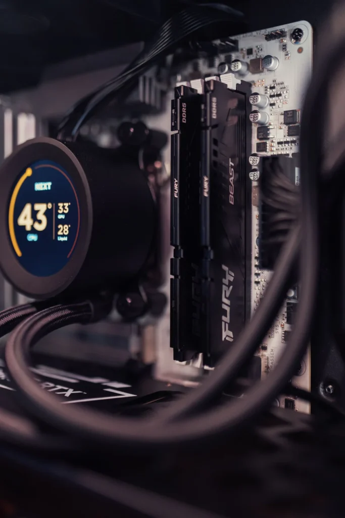 A processor cooler with a digital temperature display beside two installed black memory sticks.