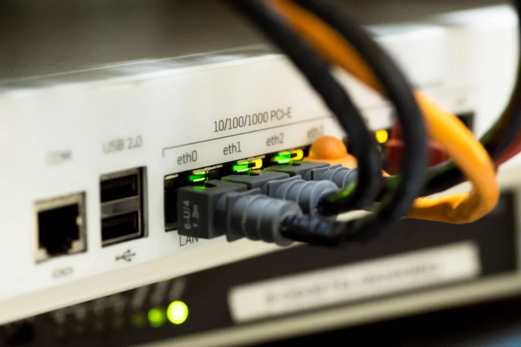 Ethernet cables plugged into network equipment beside illuminated status lights.